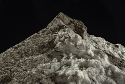 light shines on a dirty pile of snow 