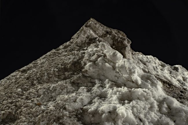light shines on a dirty pile of snow